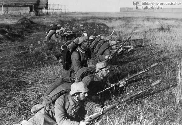 Deutsche Infanteristen mit schussbereitem Gewehr in der vordersten Linie (1914)